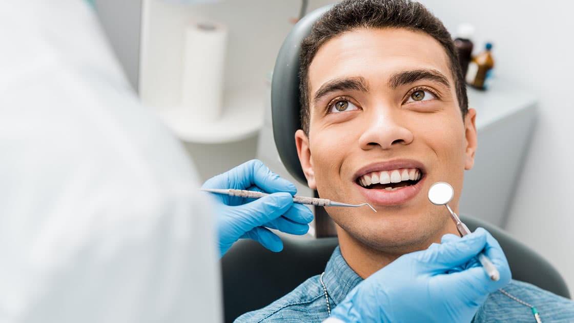 young man in dental chair smiling