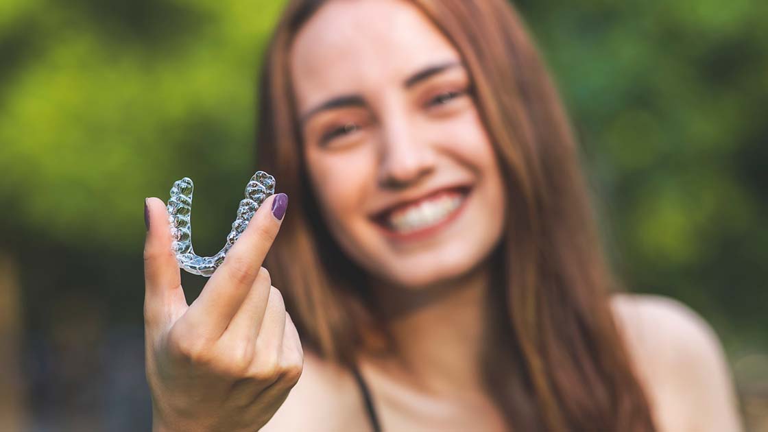 Girl holding clear aligner