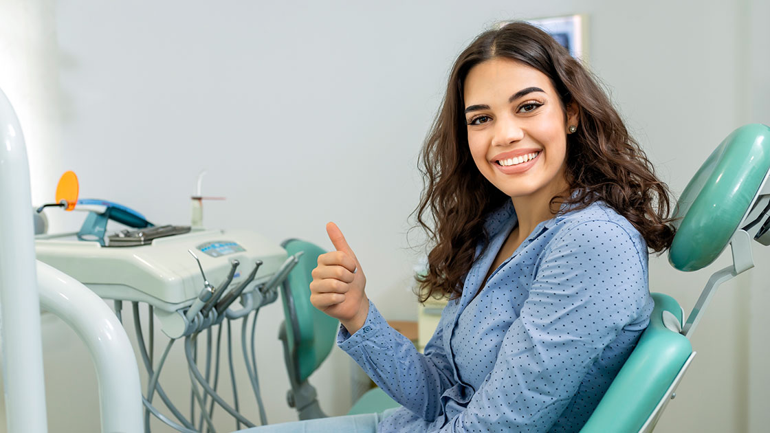 girl giving thumbs up in dental chair